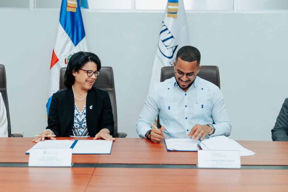Signing ceremony with representatives seated at conference table with institutional flags