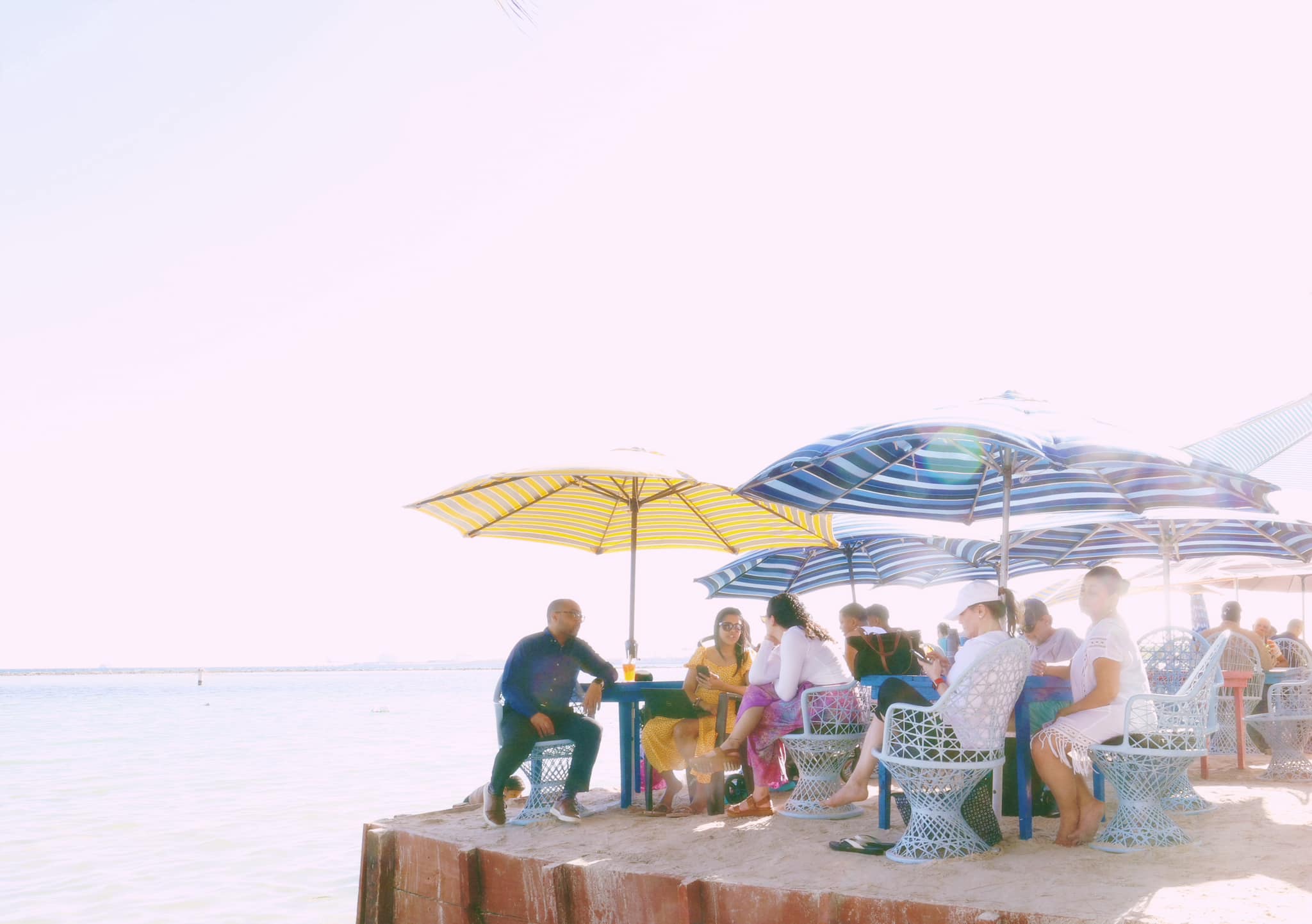 Tropical fruit juice with pineapple garnish against ocean backdrop