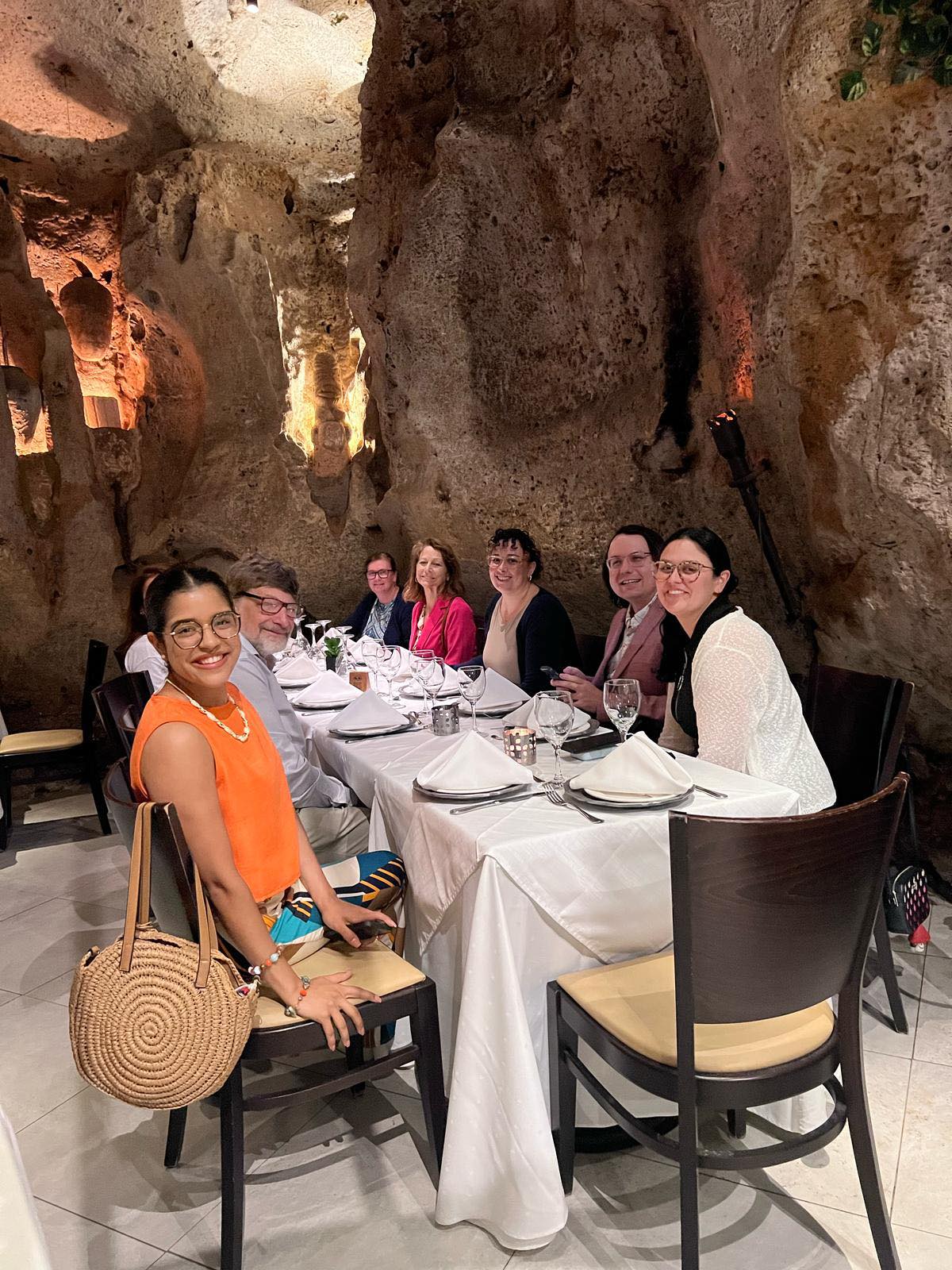 Delegation dining at tables set within the atmospheric cave setting