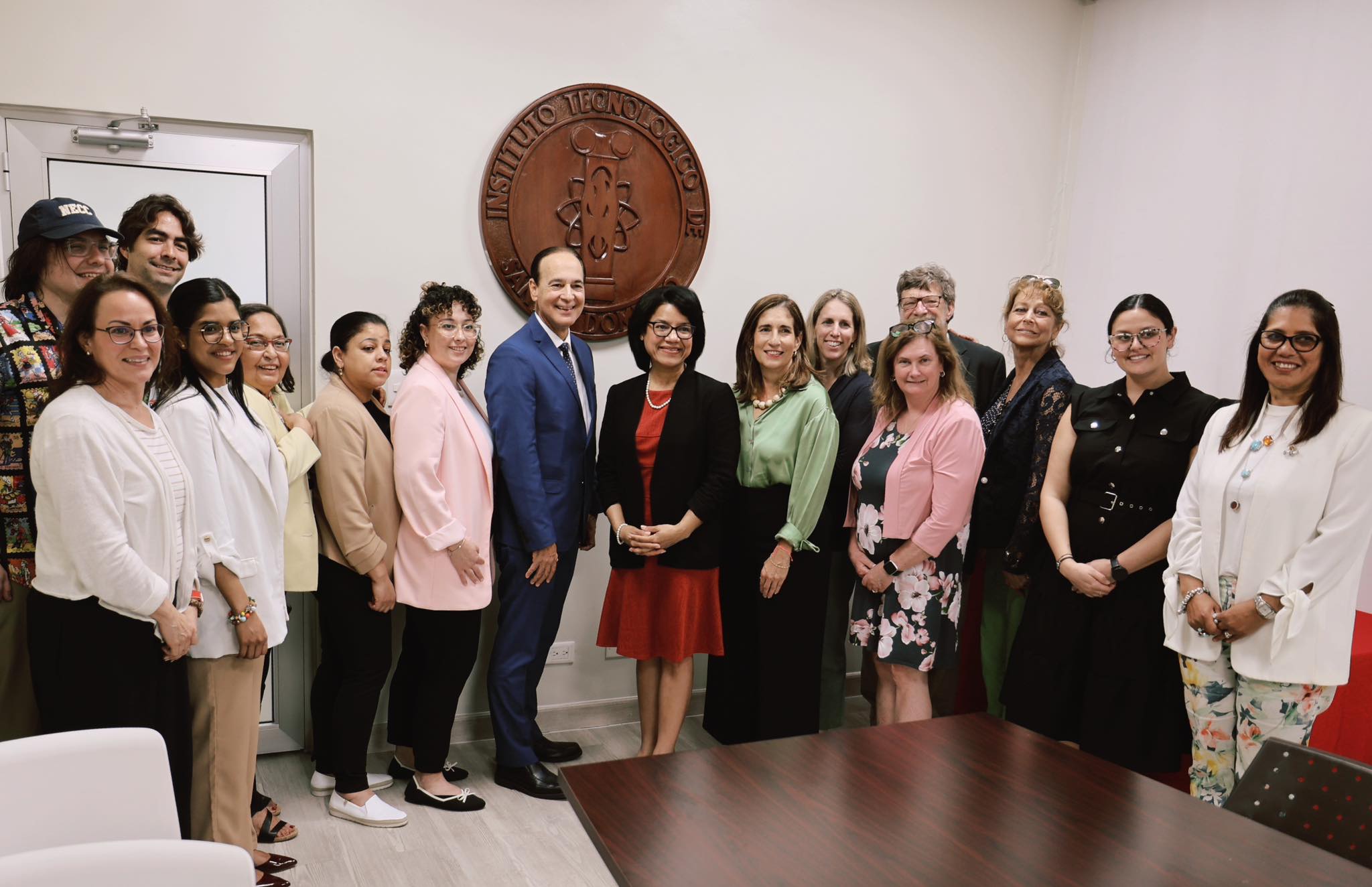 Group photo with Academic Vice President Arturo del Villar and INTEC team in front of institutional seal