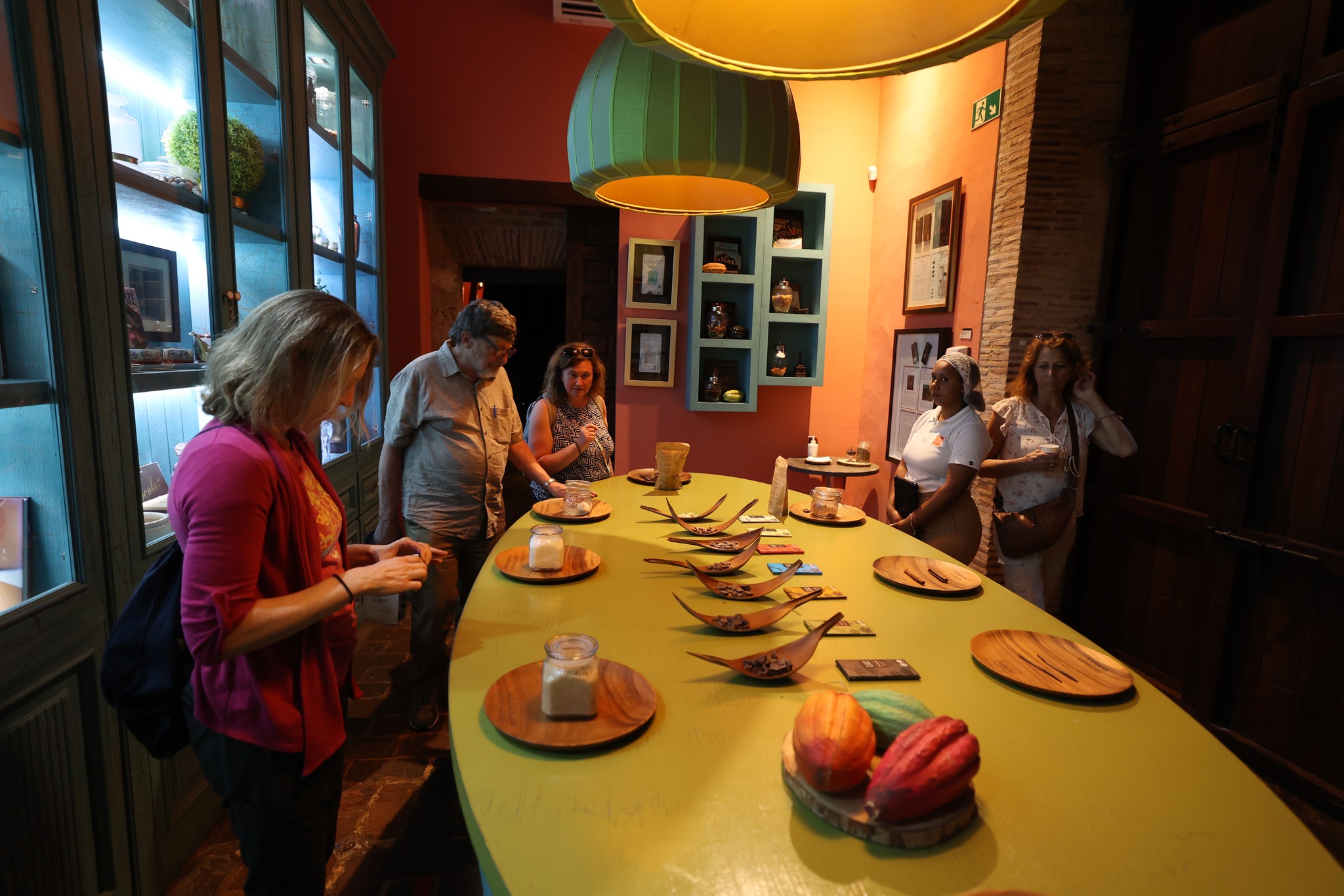 Tasting session with delegation members around oval table with wooden plates and cacao pods