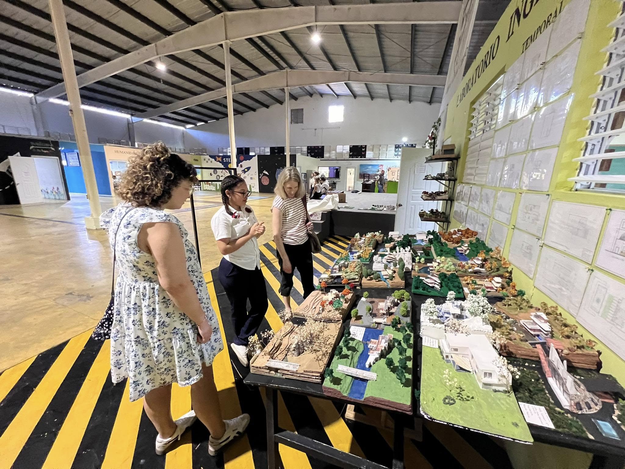 Student presenting architectural models and sustainable development projects to visitors