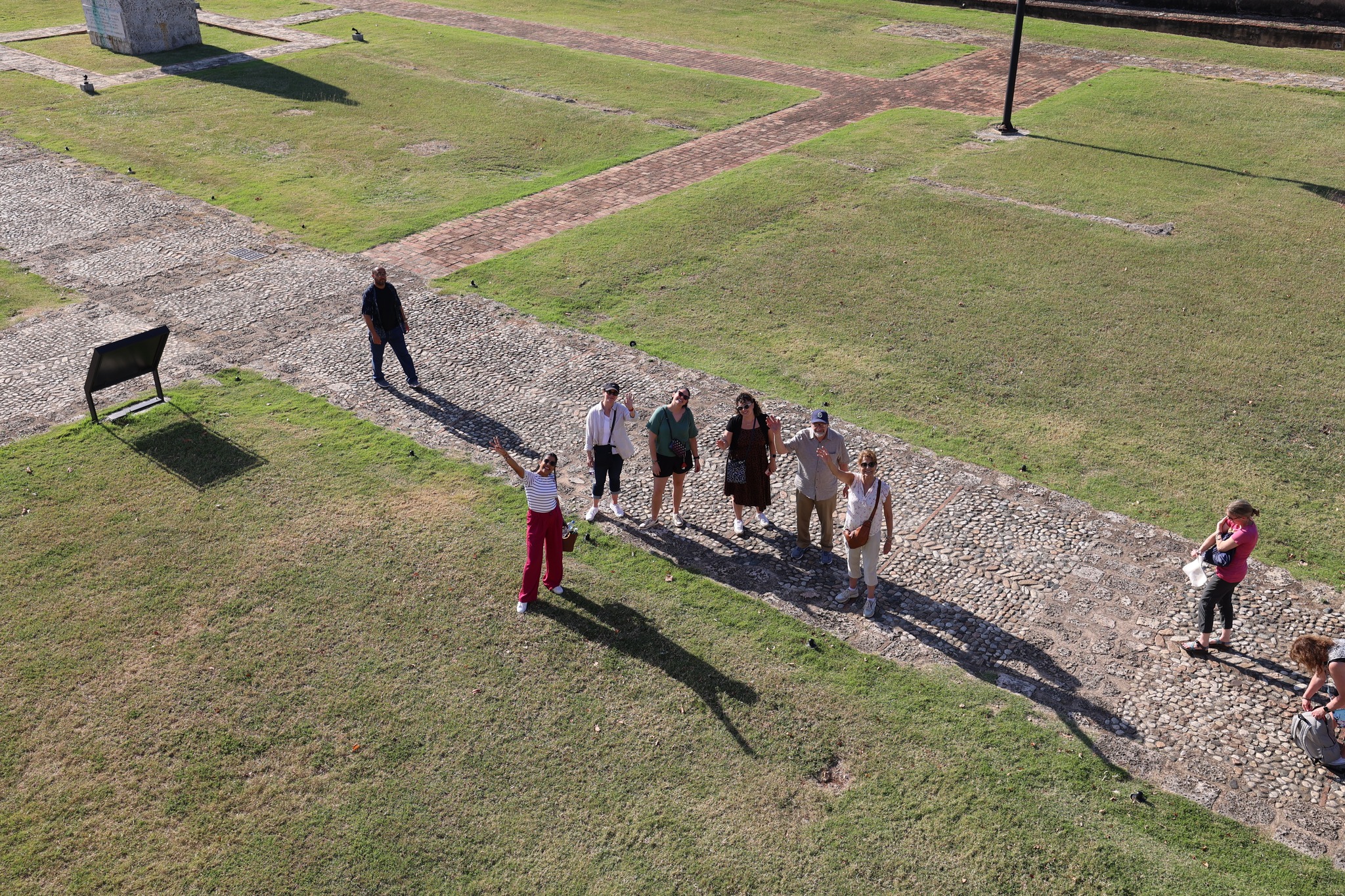 Delegation members walking along stone paths in the open grounds of the fortress