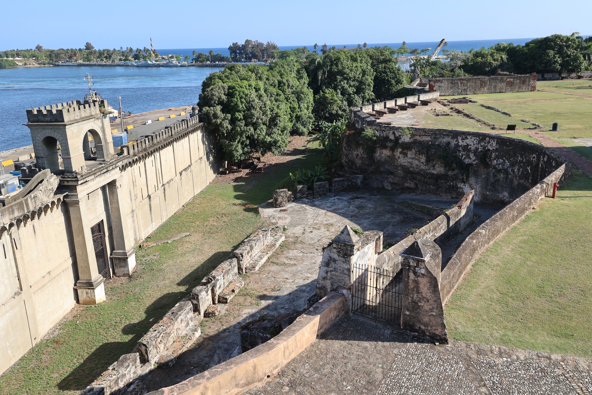 Panoramic view from fortress showing walls, former moat, and Ozama River meeting the Caribbean Sea