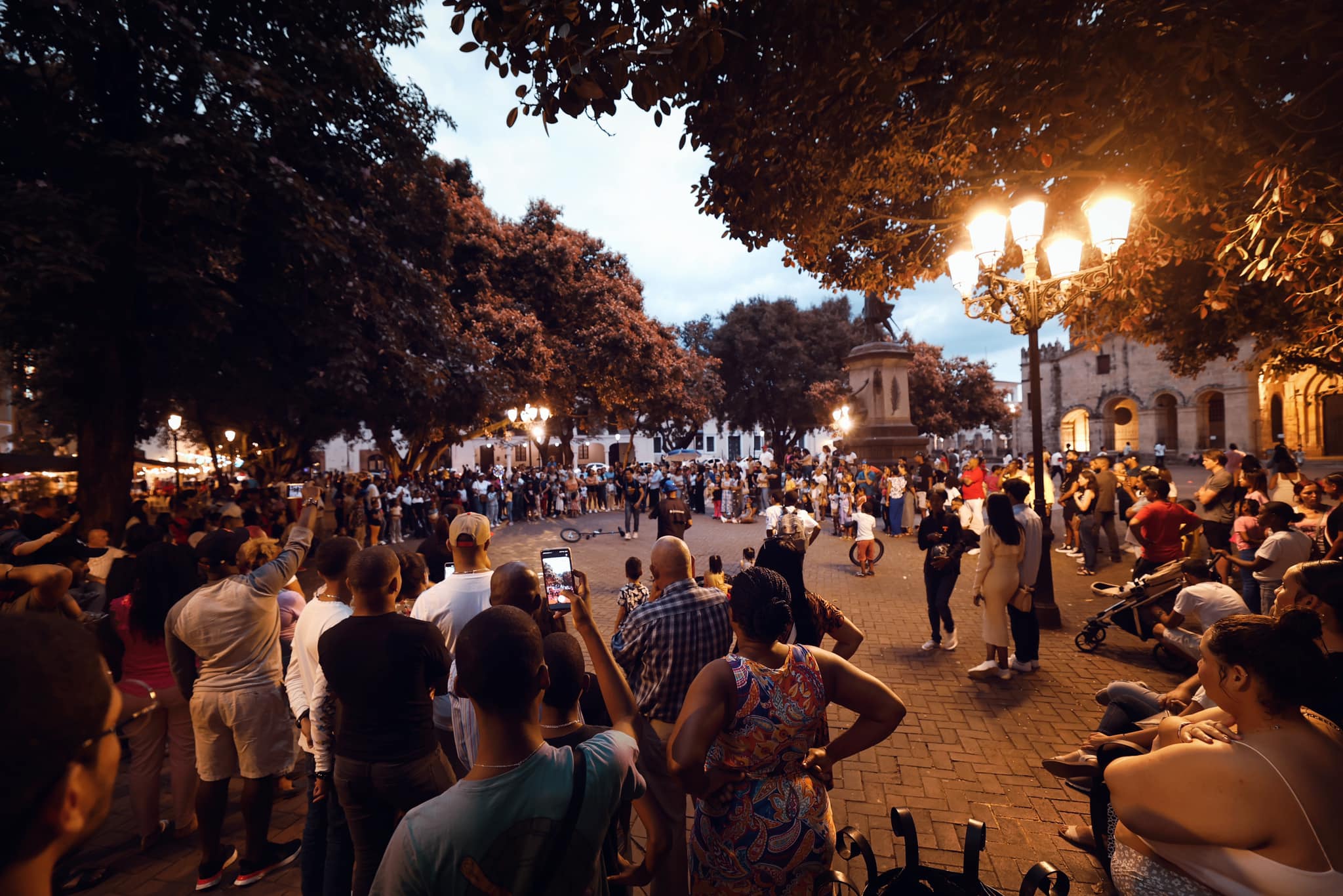 Evening gathering at Parque Colón with crowds watching street performers