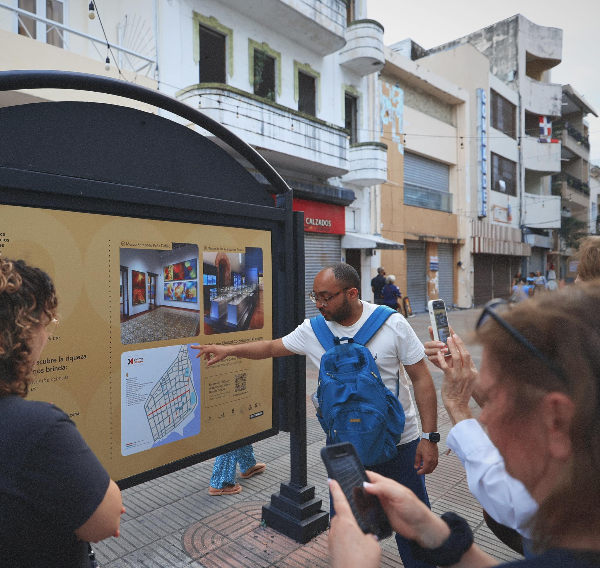 Rafael pointing out museums and attractions on an information sign
