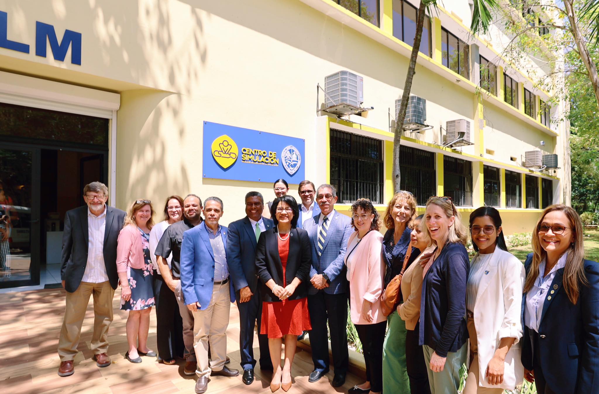 Group photo outside Centro de Simulación with UASD logo