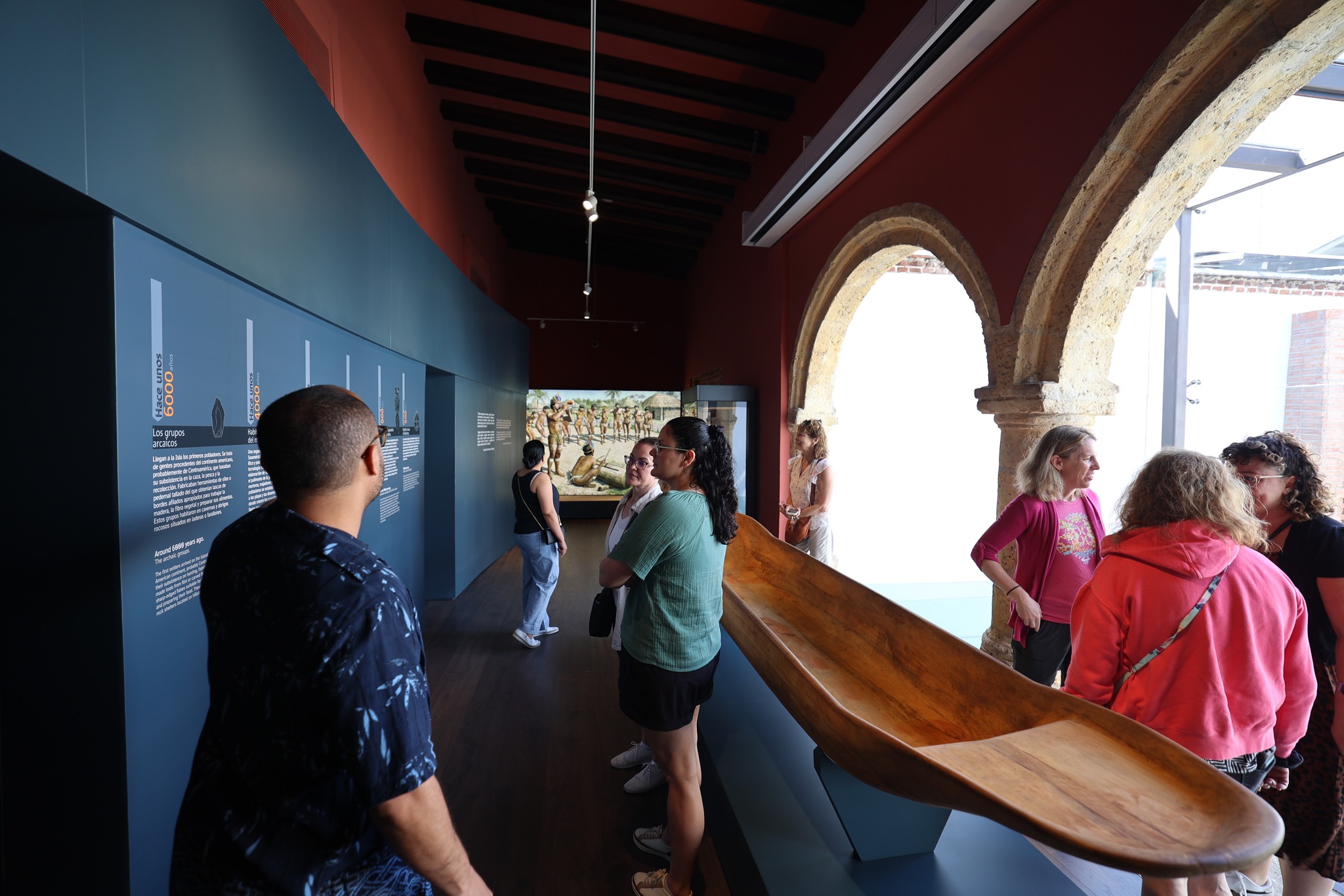 Historical exhibit with wooden canoe and informational panels about indigenous groups