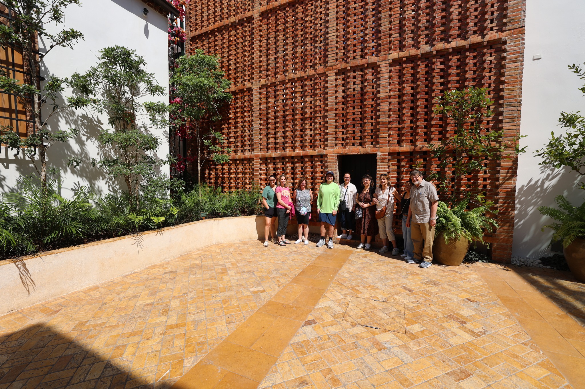 Group photo of delegation in front of the museum's distinctive brick latticework architecture