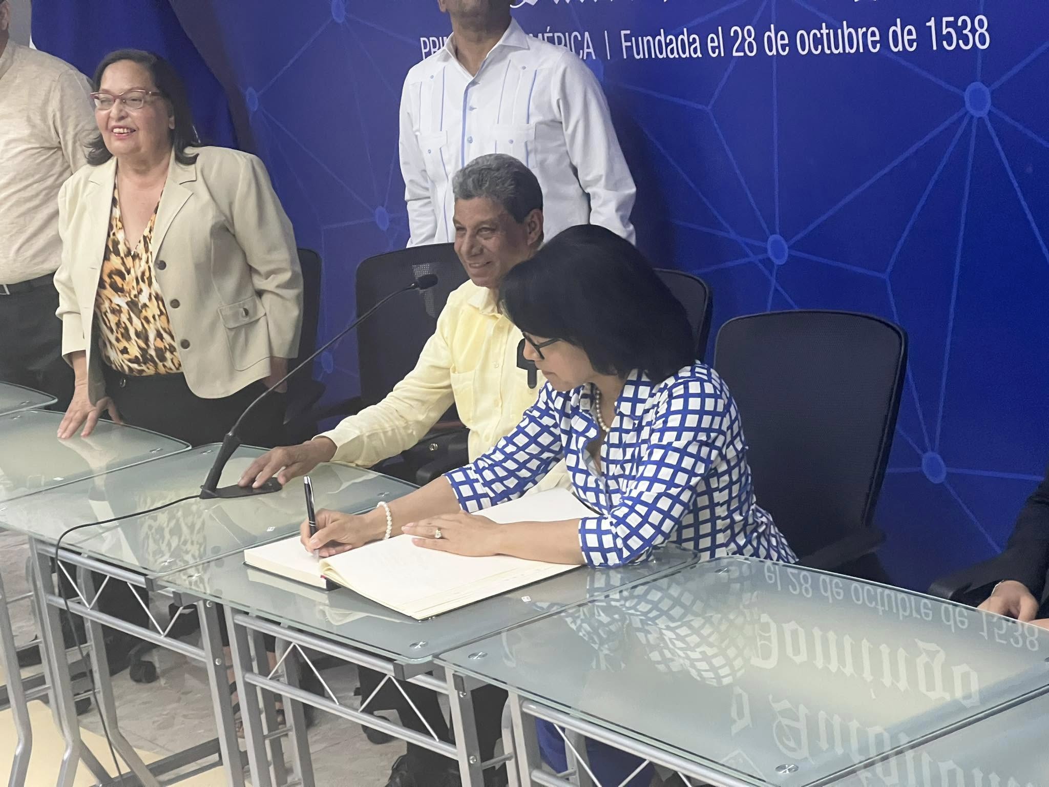 Symbolic signing ceremony with university officials at presentation table